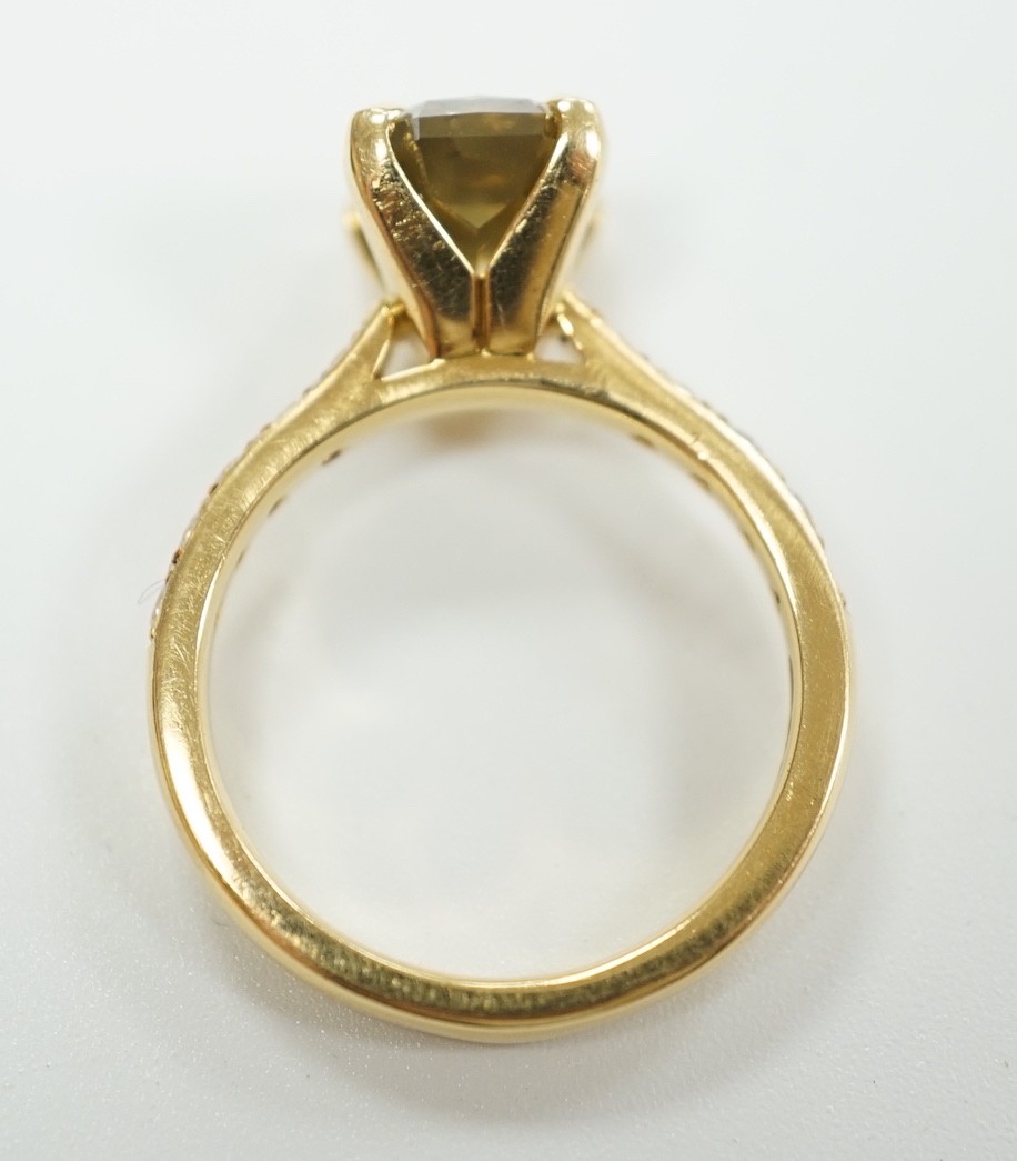 A modern 18ct gold and single stone cut cornered rectangular modified brilliant cut fancy dark brown-greenish yellow diamond, with diamond set shoulders and accompanying GIA report dated 20/12/2013, stating the stone to